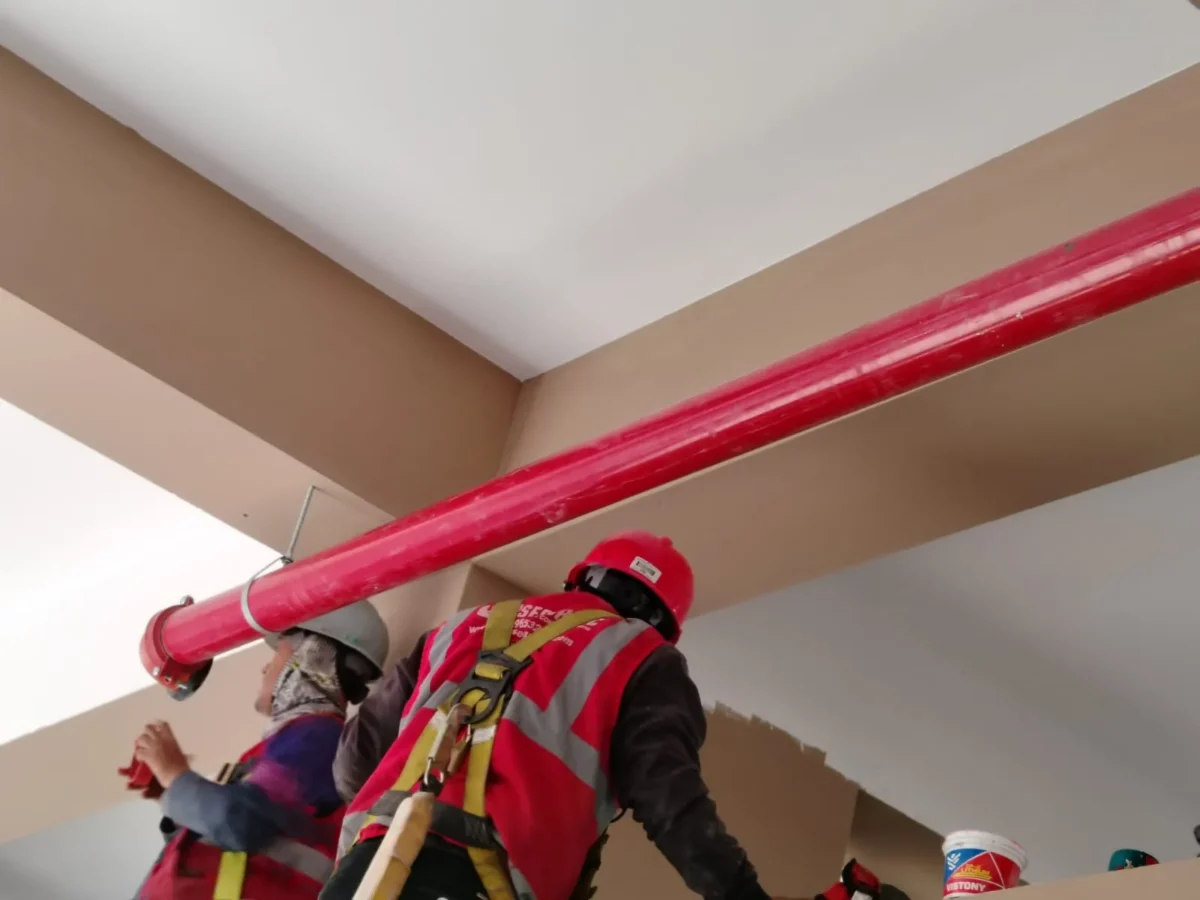 Técnicos acoplando un tramo de tubería contra incendio