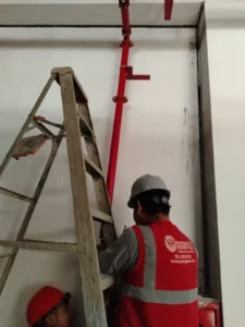 Técnicos instalando la bajada de tubería hacia un gabinete contra incendio
