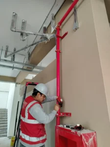 Técnico conectando la bajada de tubería a un gabinete contra incendio