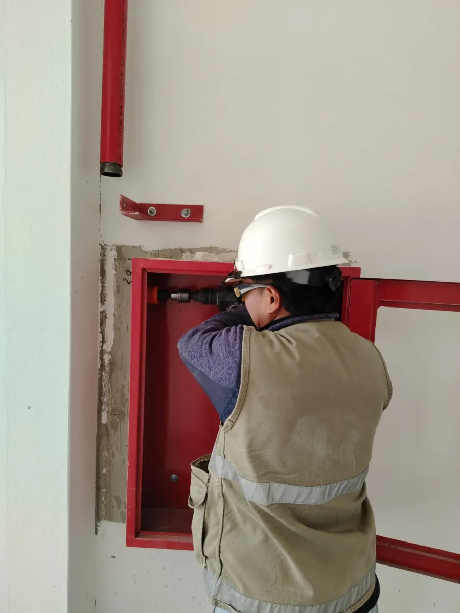 Técnico fijando un gabinete contra incendio empotrado