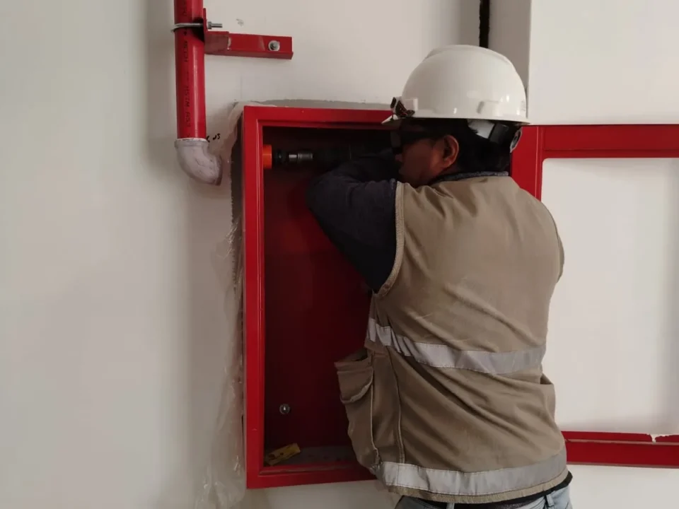 Técnico instalando un gabinete contra incendio con conexión a la bajada