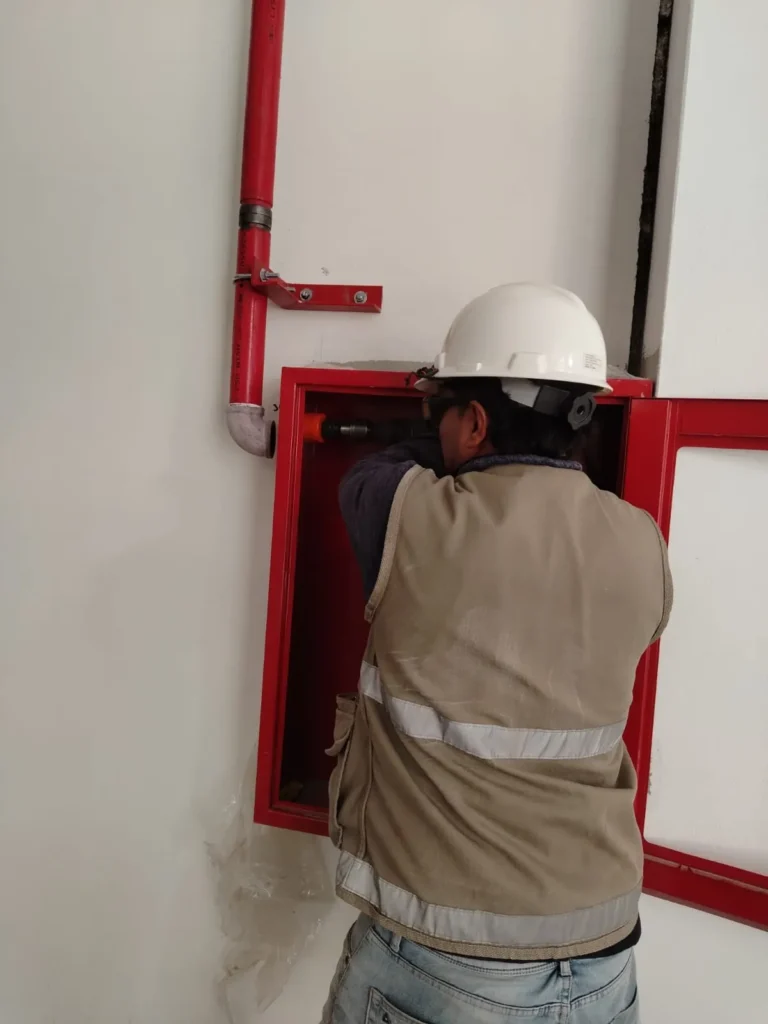 Técnico instalando un gabinete contra incendio empotrado en la pared