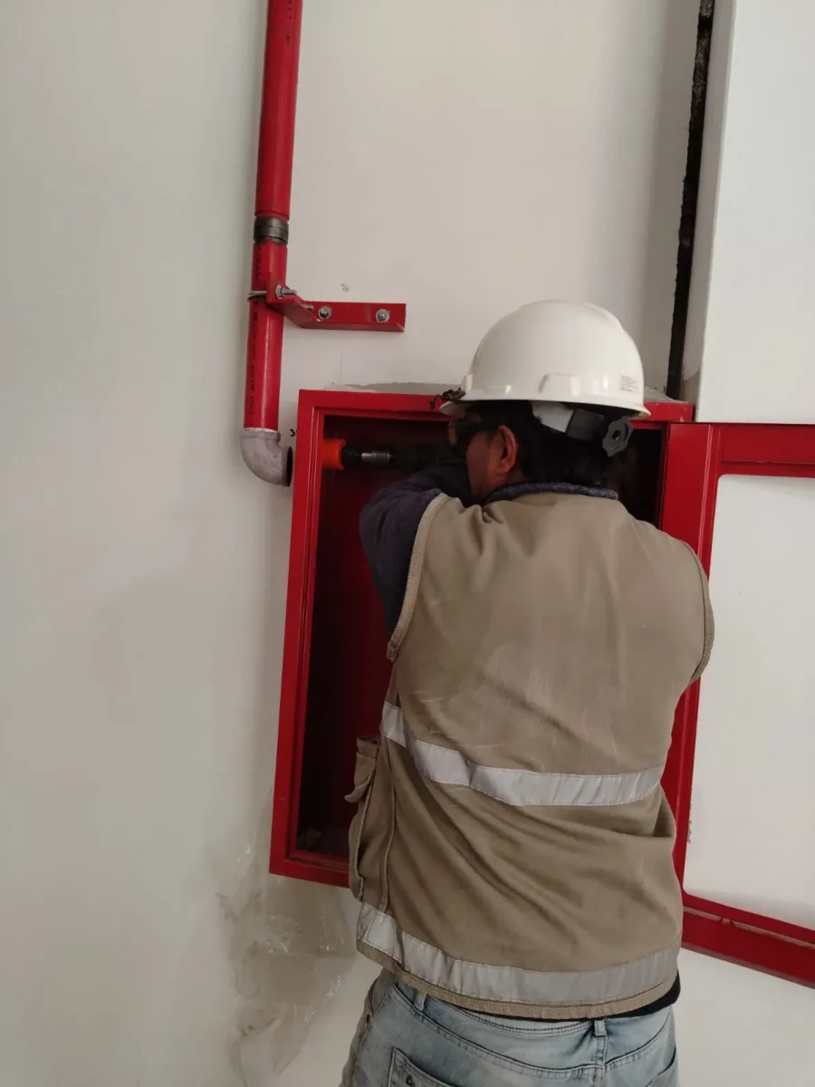 Técnico instalando un gabinete contra incendio empotrado en la pared