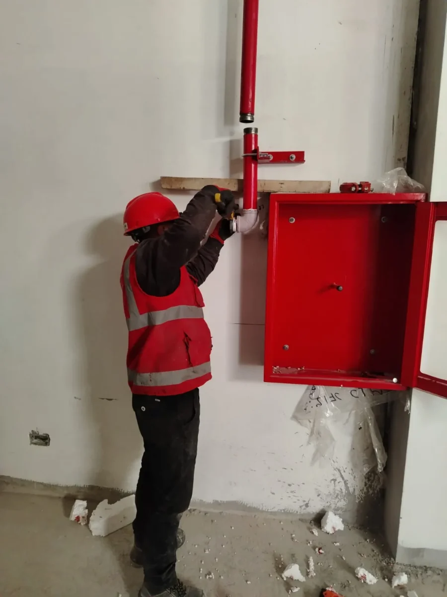 Técnico instalando un gabinete contra incendio en la pared