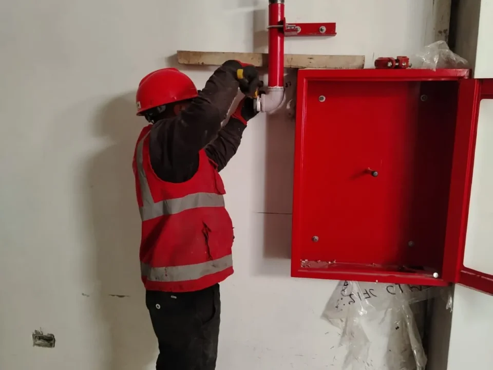 Técnico instalando un gabinete contra incendio en la pared