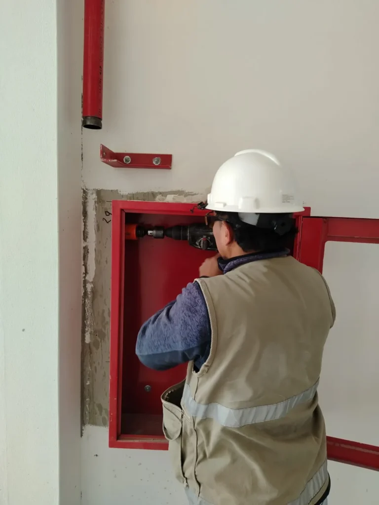 Técnico con casco montando la caja de un gabinete contra incendio