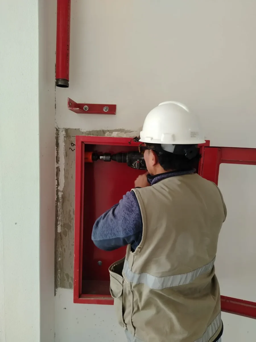 Técnico con casco montando la caja de un gabinete contra incendio