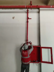Técnico montando un gabinete contra incendio bajo la bajada de tubería