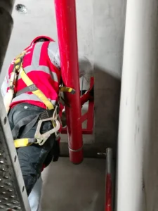 Técnico con arnés fijando el soporte de un montante en ducto