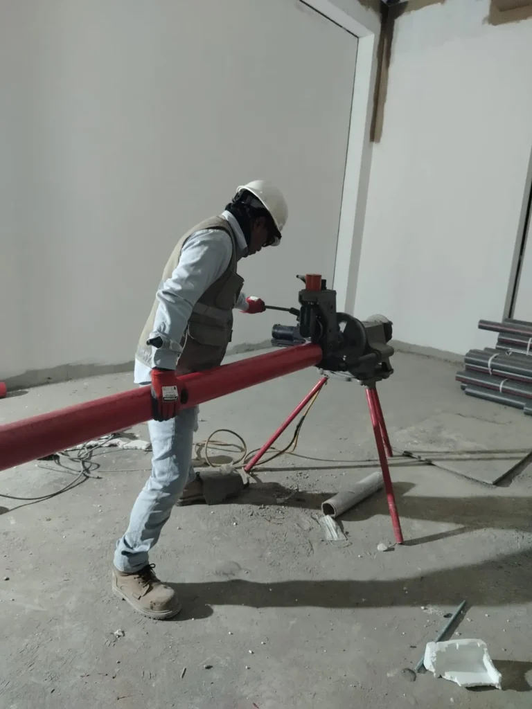 Técnico preparando tubería contra incendio con máquina sobre trípode