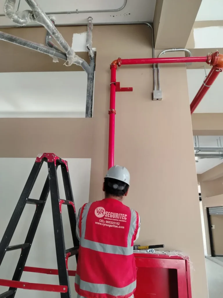 Técnico de VYR SEGURITEC instalando tubería hacia un gabinete contra incendio